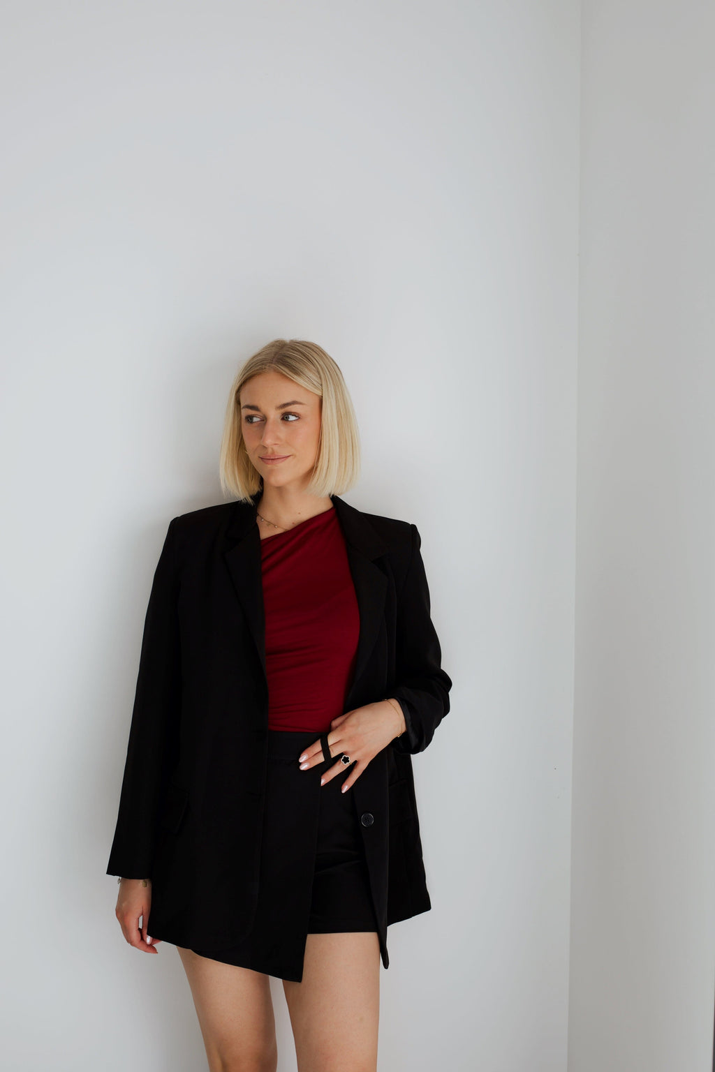 Model wearing a stylish one-shoulder burgundy top with a draped design, creating an elegant and modern look, ideal for evening wear or special occasions.